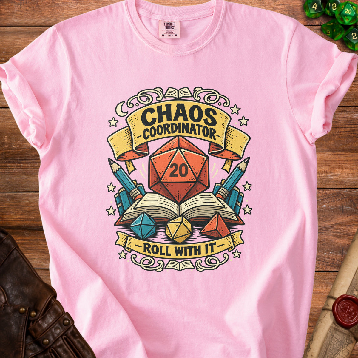 Pink t-shirt with "Chaos Coordinator Roll With It" text and D20 dice graphics.