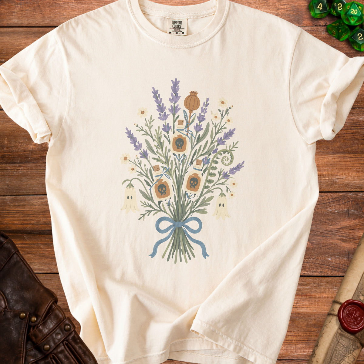Cream t-shirt with a watercolor bouquet featuring skulls, ghosts, and potion bottles.