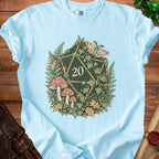 Light blue t-shirt with a forest-themed d20 die, moths, mushrooms, and ferns design.