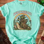 Mint t-shirt with graphic of goblin riding snail under rainbow, "Socially Unavailable" and "gone foraging" text.