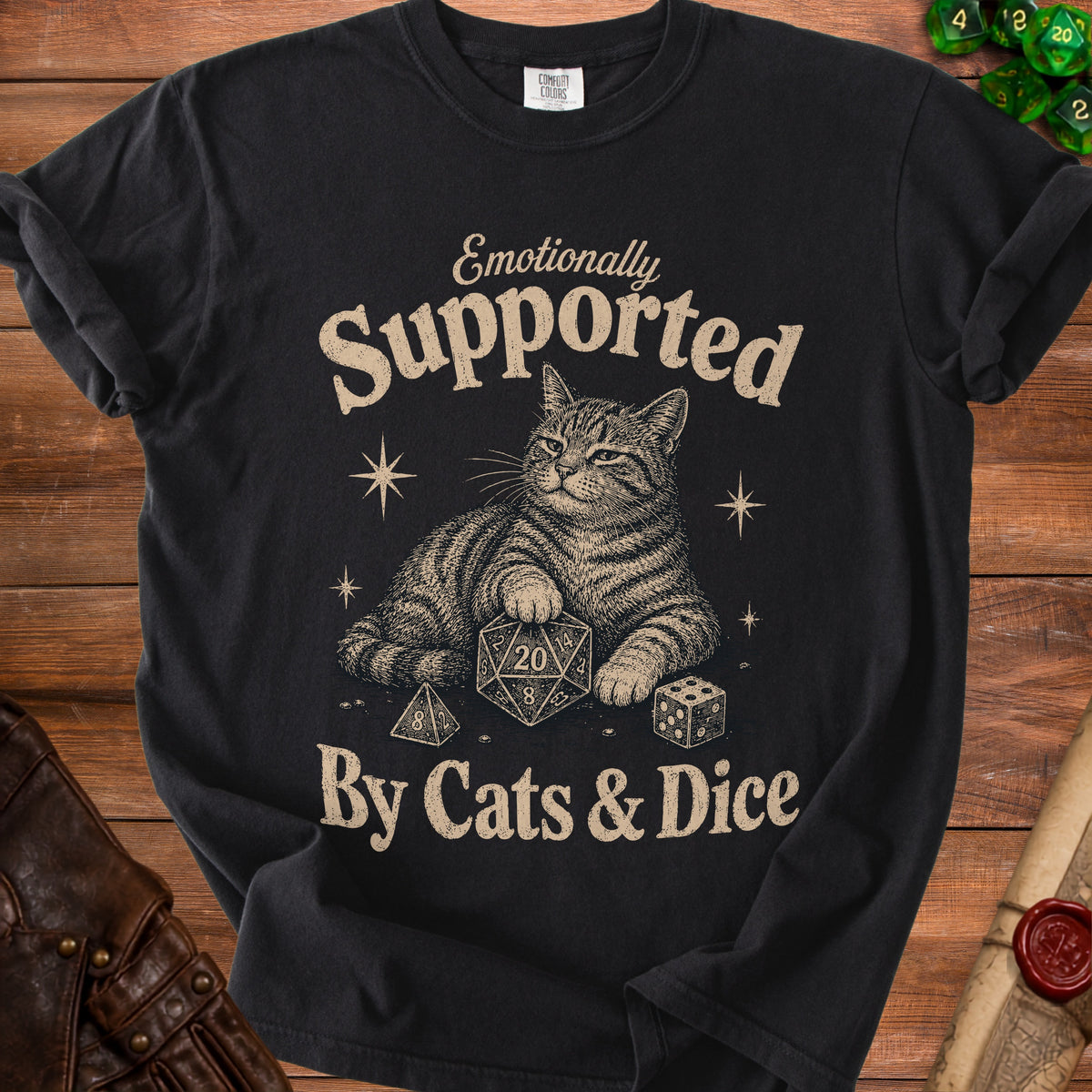Black t-shirt with a tabby cat and dice graphic reading "Emotionally Supported By Cats & Dice".