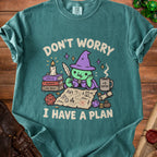 Green t-shirt with a cartoon witch planning a quest on a treasure map.