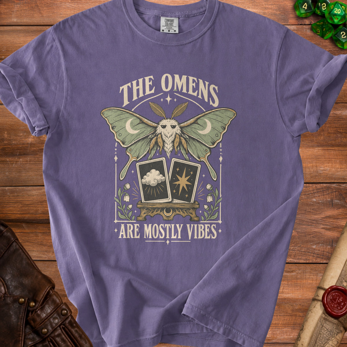 Purple t-shirt with moth, tarot cards, and text "The Omens Are Mostly Vibes".