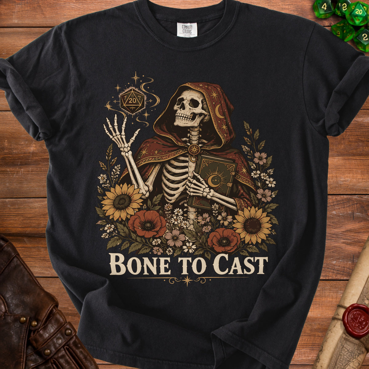 Skeleton in hooded robe holds book surrounded by flowers and dice, "Bone to Cast" text.