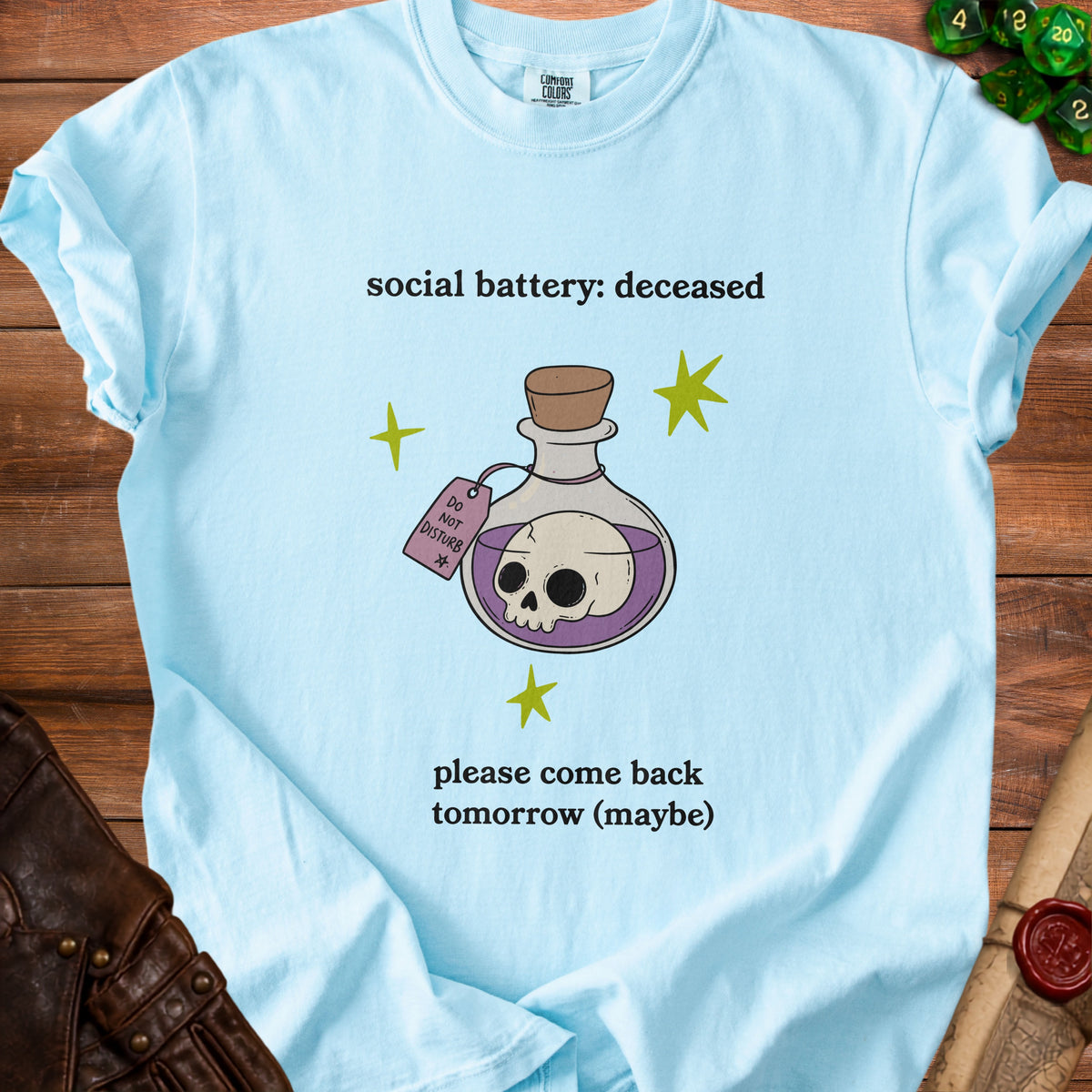 Light blue t-shirt with "social battery: deceased" and skull in potion.