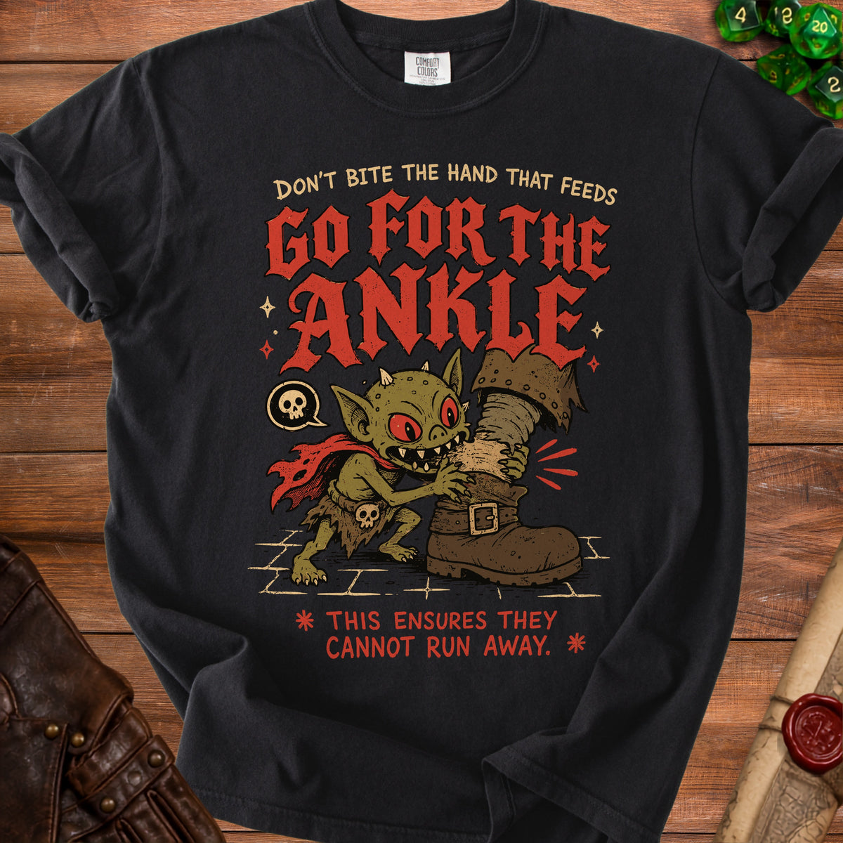 Black t-shirt with a goblin biting a boot, text reads "Go for the Ankle."
