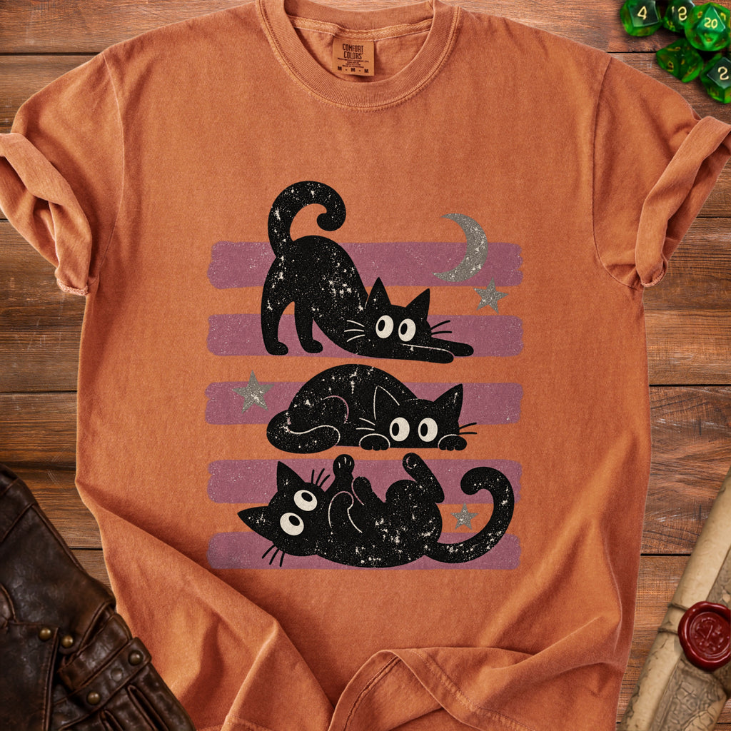 Orange t-shirt with a graphic of two black cats, a moon, and stars.