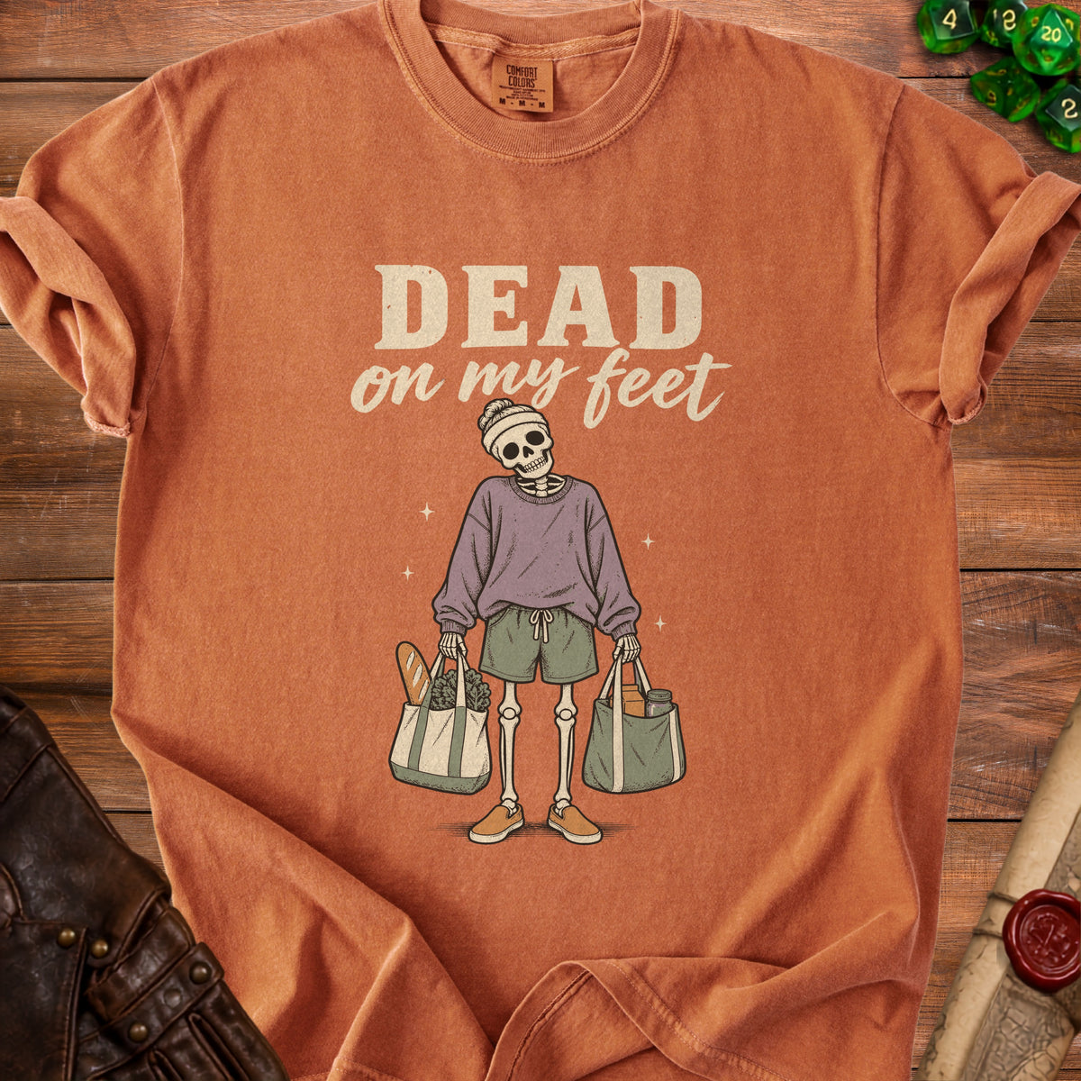 T-shirt with a skeleton graphic holding grocery bags and text "DEAD on my feet".