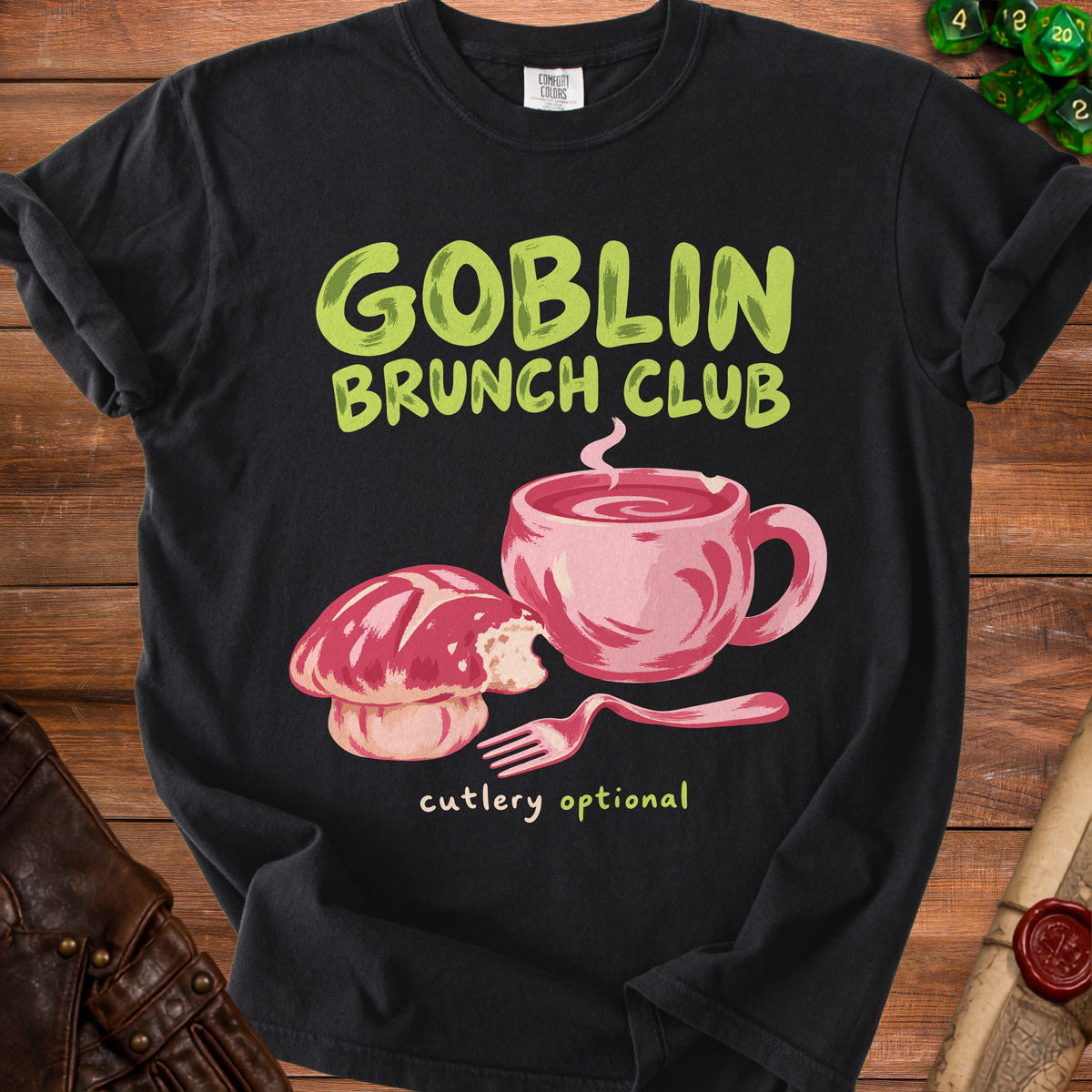Black t-shirt with "Goblin Brunch Club" text, a pink pastry, and a mug.