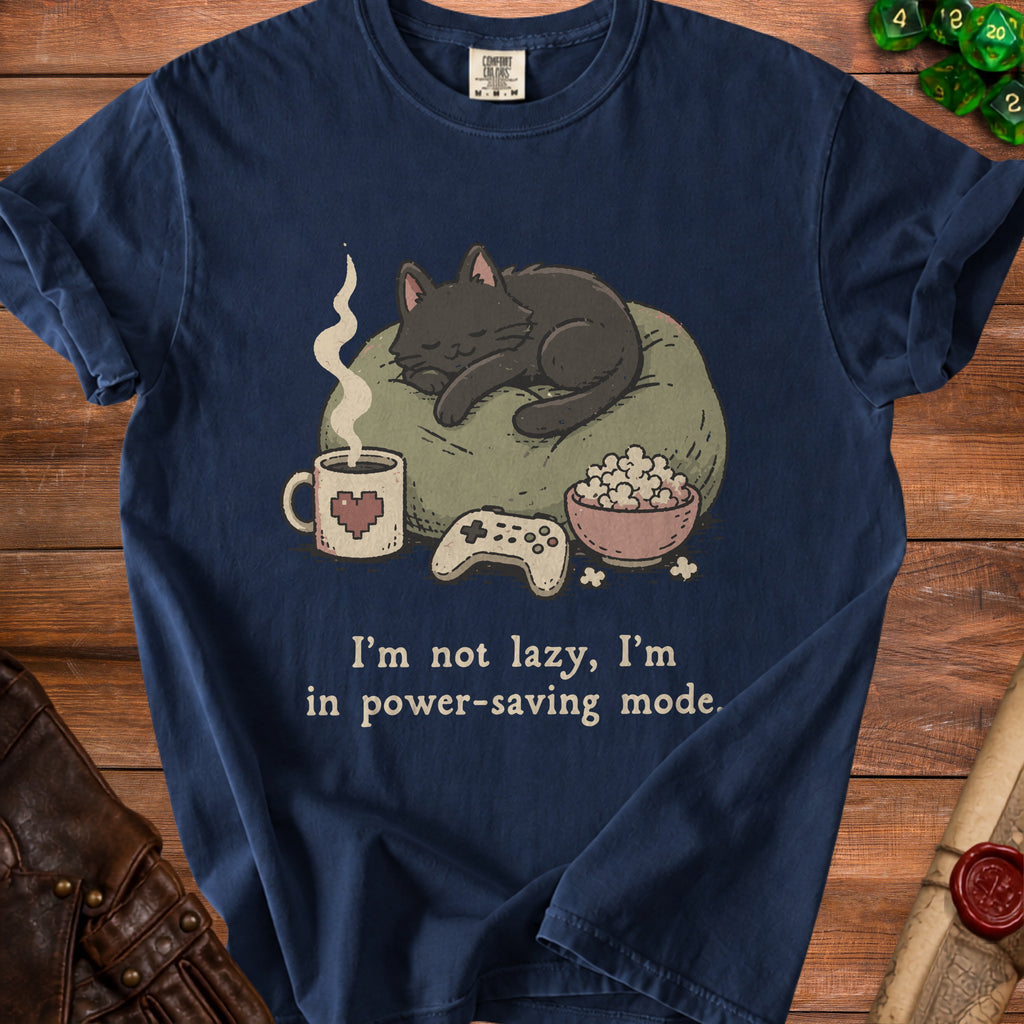 Navy t-shirt with a black cat sleeping on a pillow, game controller, popcorn, and coffee.