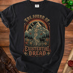 Black t-shirt with skeleton, cat, mountains, rainbow, and text "THE SOUND OF EXISTENTIAL DREAD."