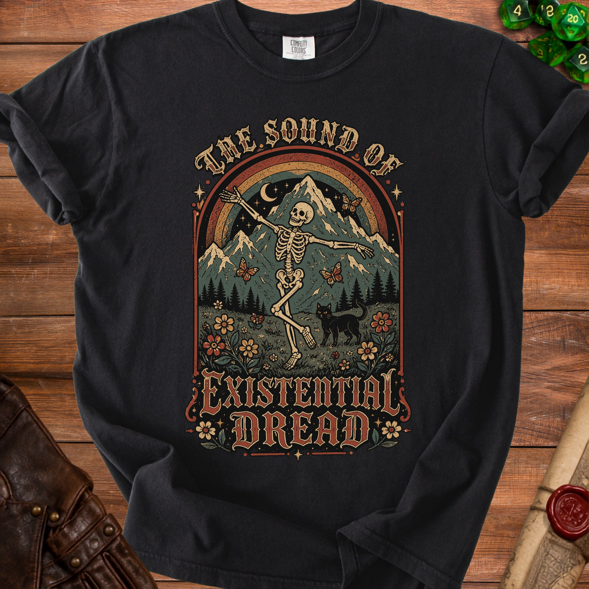 Black t-shirt with skeleton, cat, mountains, rainbow, and text "THE SOUND OF EXISTENTIAL DREAD."