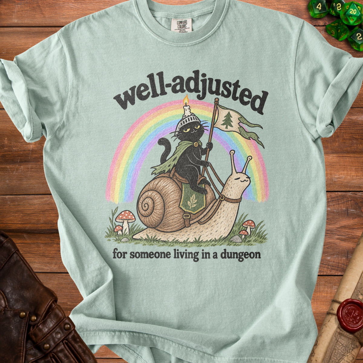 Light green t-shirt with black cat riding a snail under a rainbow.
