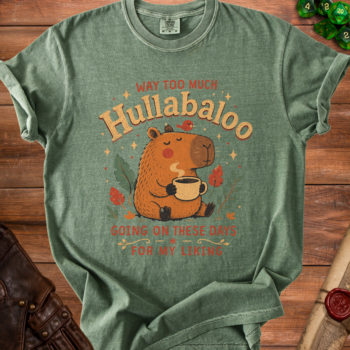 Green t-shirt with illustration of a capybara holding a coffee mug and text "Hullabaloo".