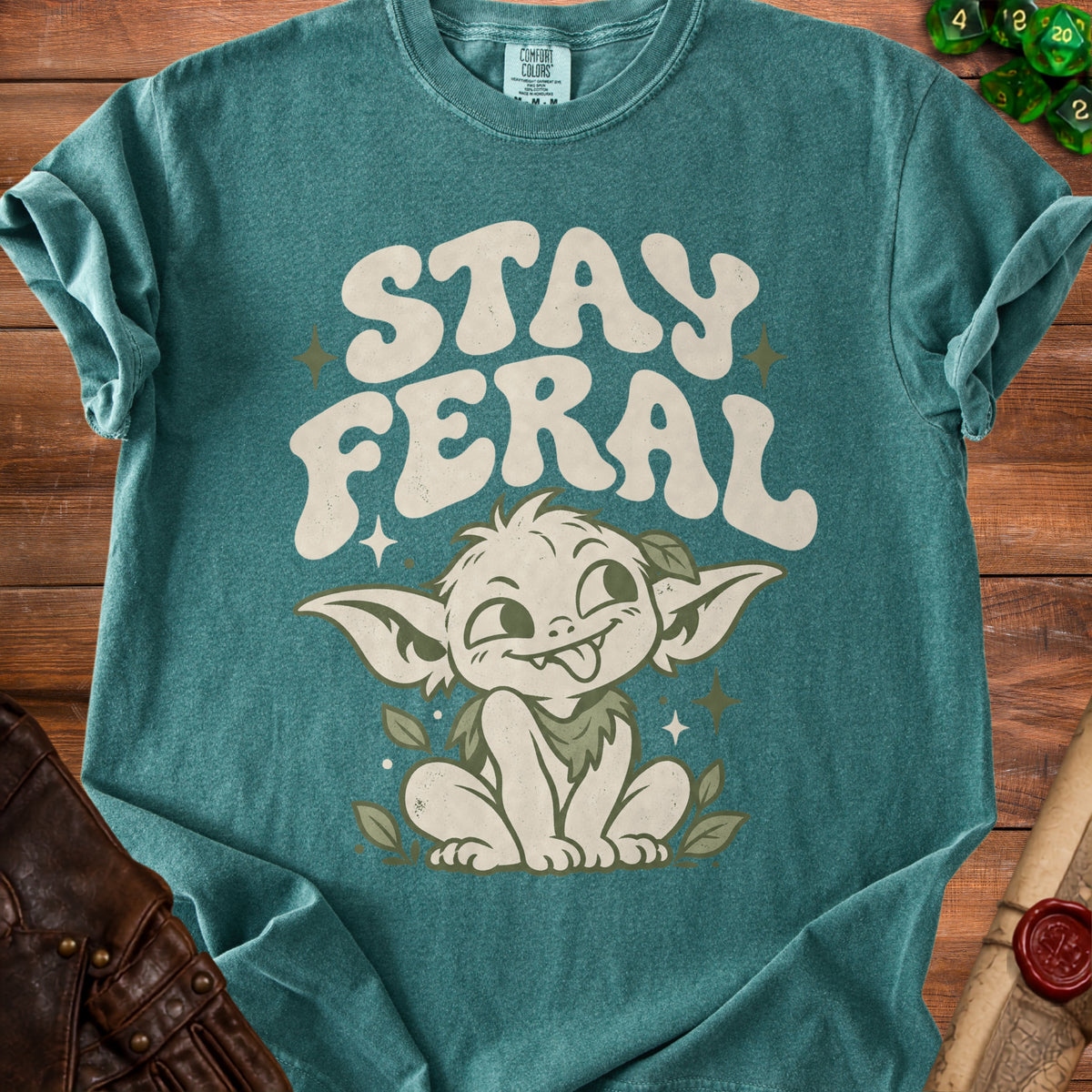 Teal t-shirt with "STAY FERAL" text and a whimsical creature illustration.