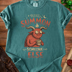 Teal t-shirt with red graphic of a monster saying "Please Summon Someone Else".
