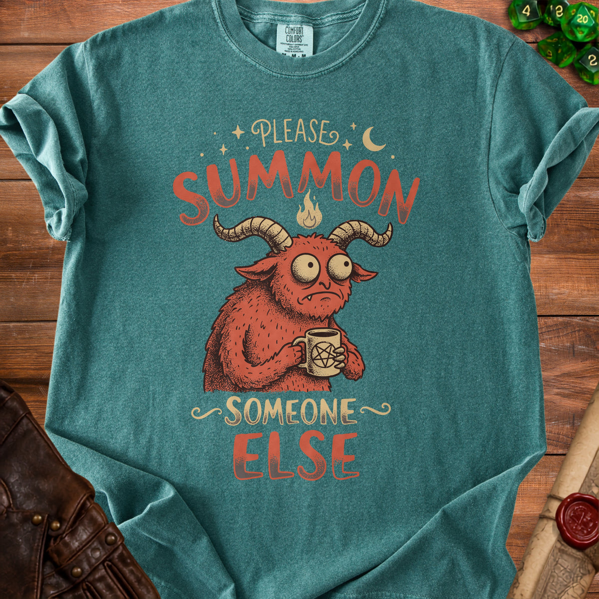 Teal t-shirt with red graphic of a monster saying "Please Summon Someone Else".