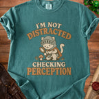 Green t-shirt with cartoon knight cat holding magnifying glass and text "I'm Not Distracted Checking Perception."