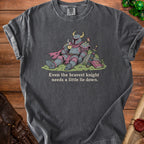 T-shirt with illustration of knight drinking tea next to sword and book, "Even the bravest knight needs a little lie down."