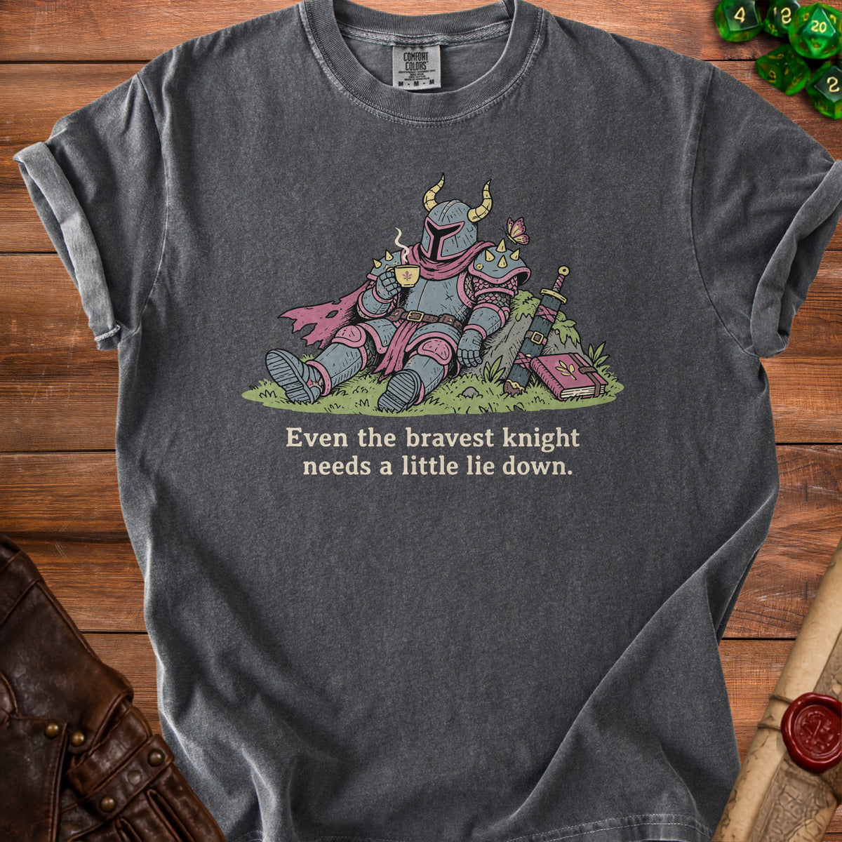 T-shirt with illustration of knight drinking tea next to sword and book, "Even the bravest knight needs a little lie down."