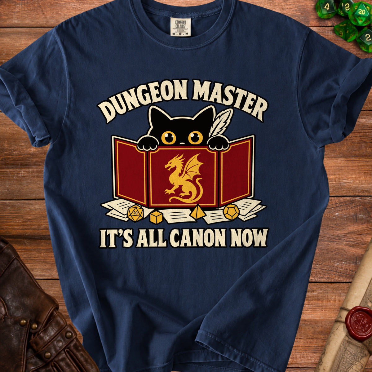 Navy t-shirt with black cat, dragon shield, dice, and text: Dungeon Master, It's All Canon Now.