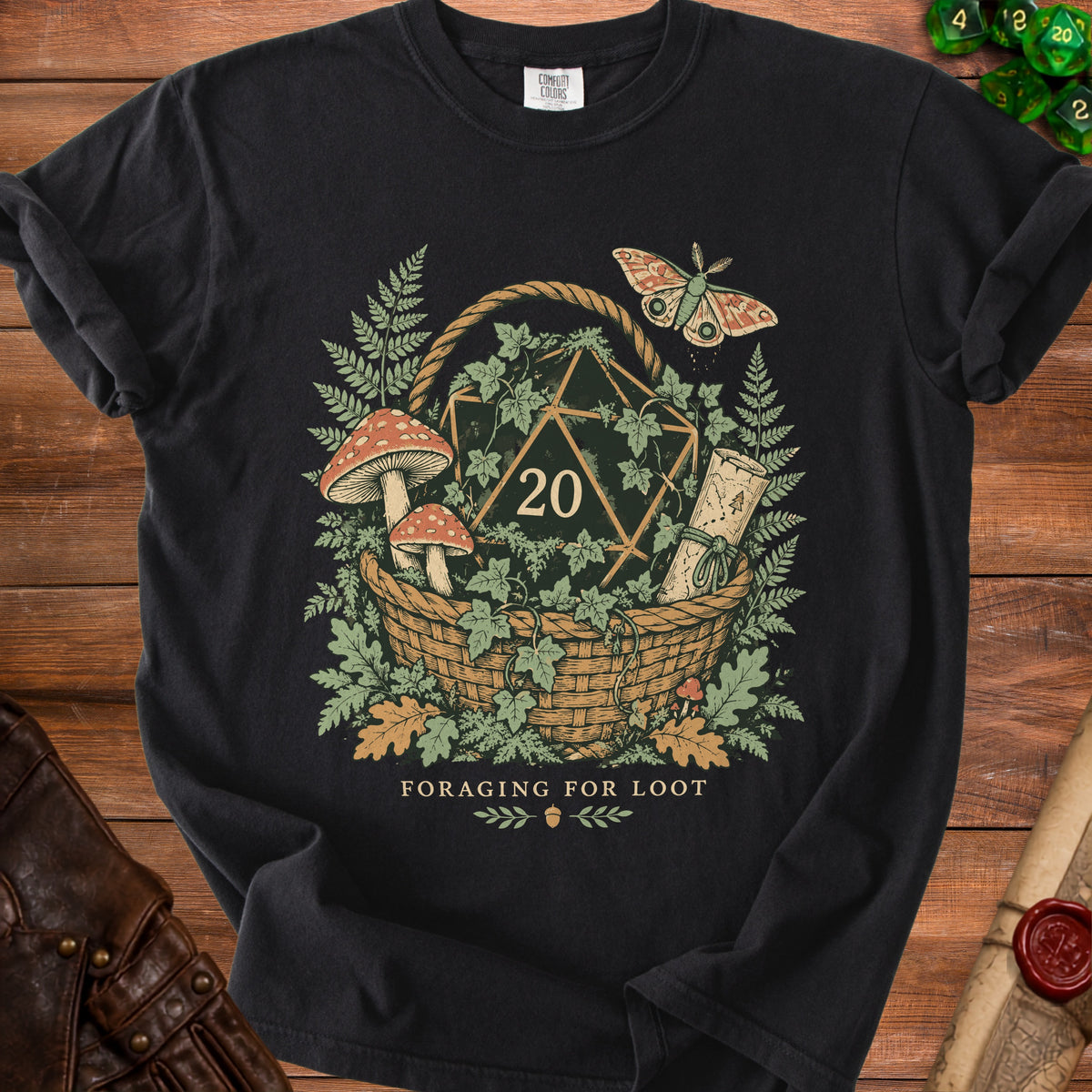 Black t-shirt graphic with d20, mushrooms, ferns, and moth with text "Foraging for Loot".