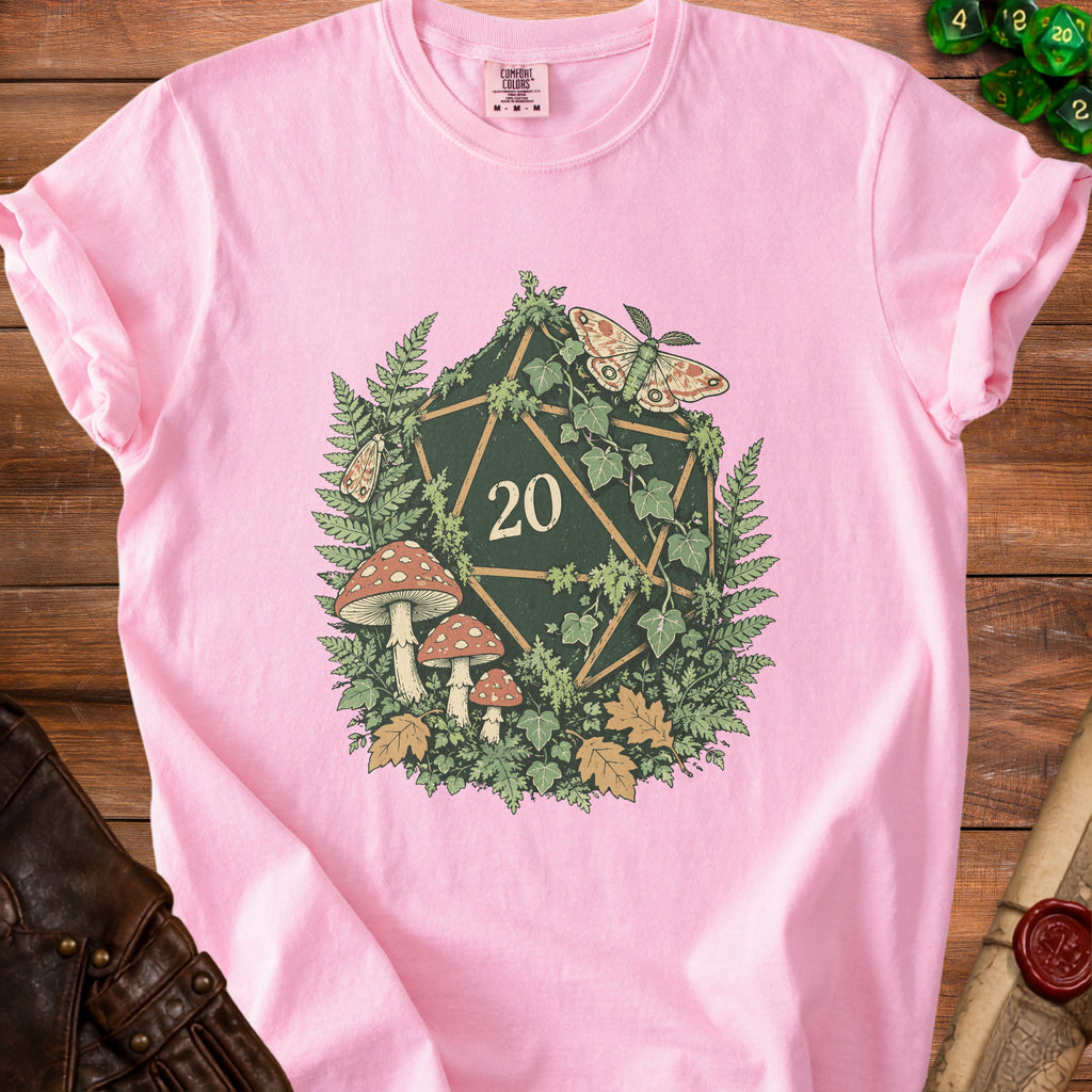 Pink t-shirt featuring a D20 die surrounded by forest elements, mushrooms, and moths.