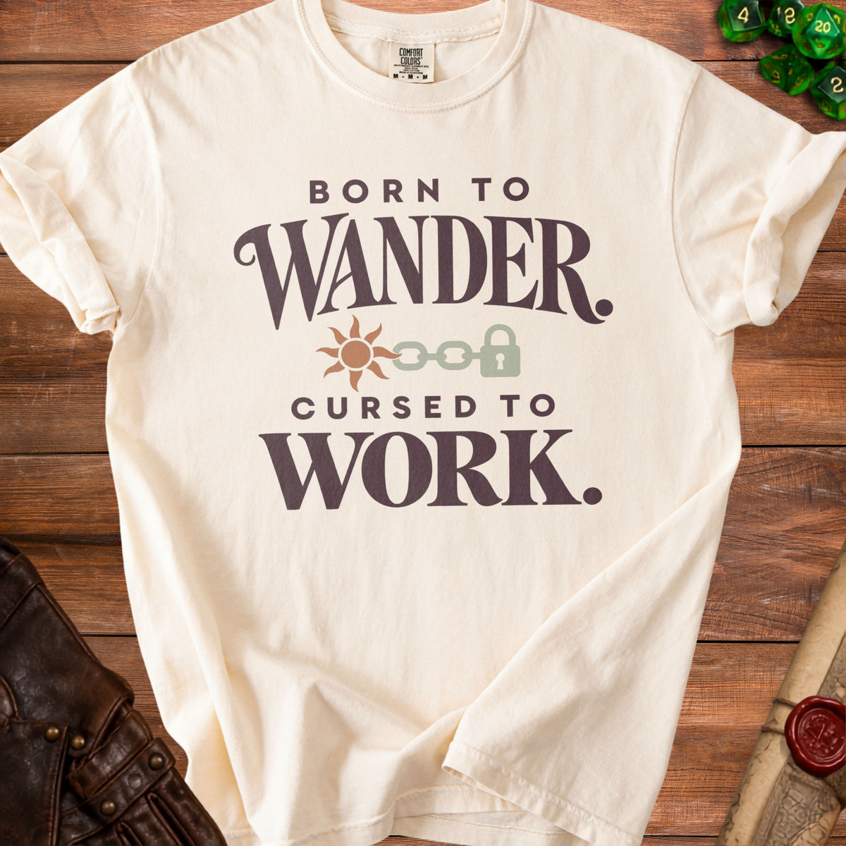 Cream t-shirt with "Born to Wander. Cursed to Work." text and graphics.