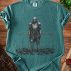 Dark teal t-shirt with a knight in armor and the text "JUST HERE TO SUFFER".