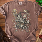 Skeleton wizard graphic with text "WELL, SHIT..." on a brown t-shirt.