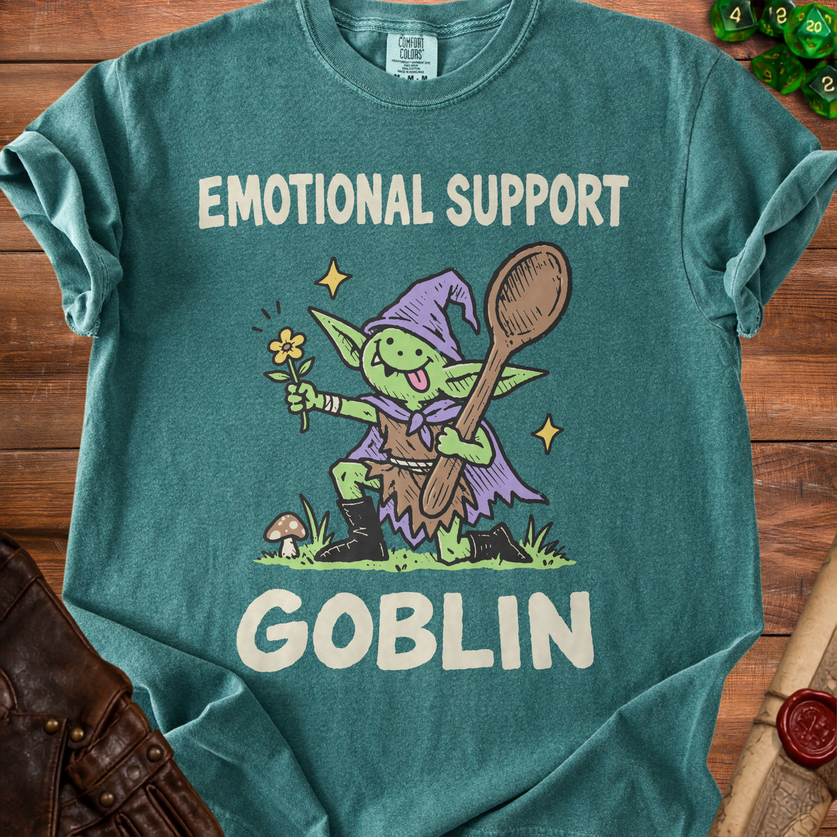 T-shirt with graphic of a goblin holding a flower and spoon, text "EMOTIONAL SUPPORT GOBLIN".