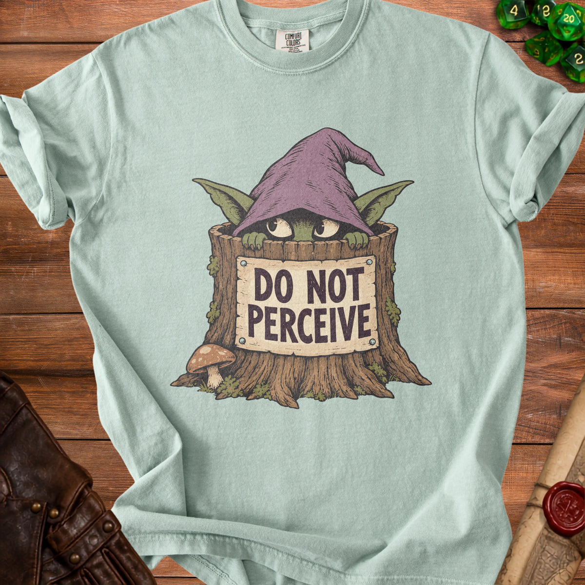 A light green t-shirt features a graphic of a creature in a tree stump holding a sign reading DO NOT PERCEIVE.