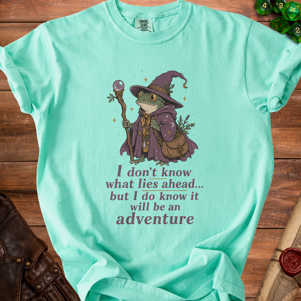 Mint t-shirt with wizard frog illustration and text: "I don't know what lies ahead... but I do know it will be an adventure".