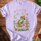 Lavender t-shirt with pastel text "Doing My Best" and a frog on a mushroom.
