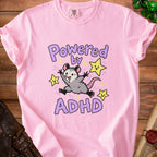 Pink t-shirt with "Powered by ADHD" text and a cartoon opossum.