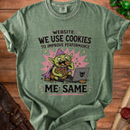 Green t-shirt with cartoon goblin eating cookies and text "WE USE COOKIES TO IMPROVE PERFORMANCE ME: SAME".