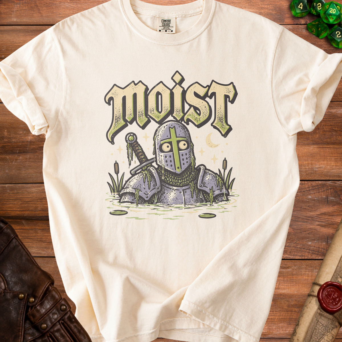 Cream t-shirt with a knight in armor standing in water with text "moist" above.
