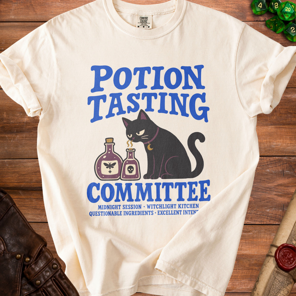 Cream t-shirt with black cat, potion bottles, and "Potion Tasting Committee" text.