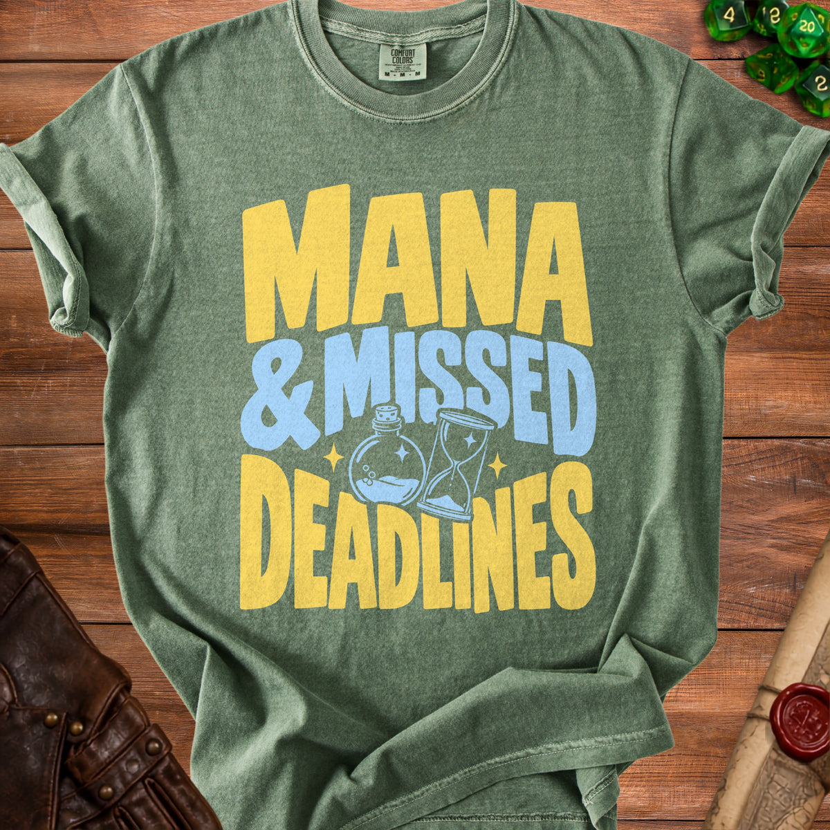 Green t-shirt with "Mana & Missed Deadlines" text and potion and hourglass graphics.