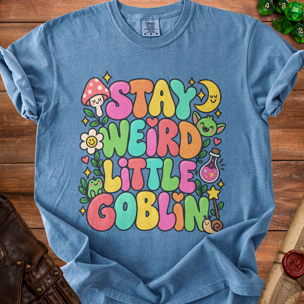 Blue t-shirt with "Stay Weird Little Goblin" text and cartoon illustrations.