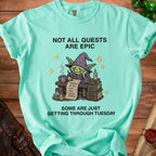 Aquamarine t-shirt with a wizard goblin and text "Not All Quests Are Epic, Some Are Just Getting Through Tuesday."