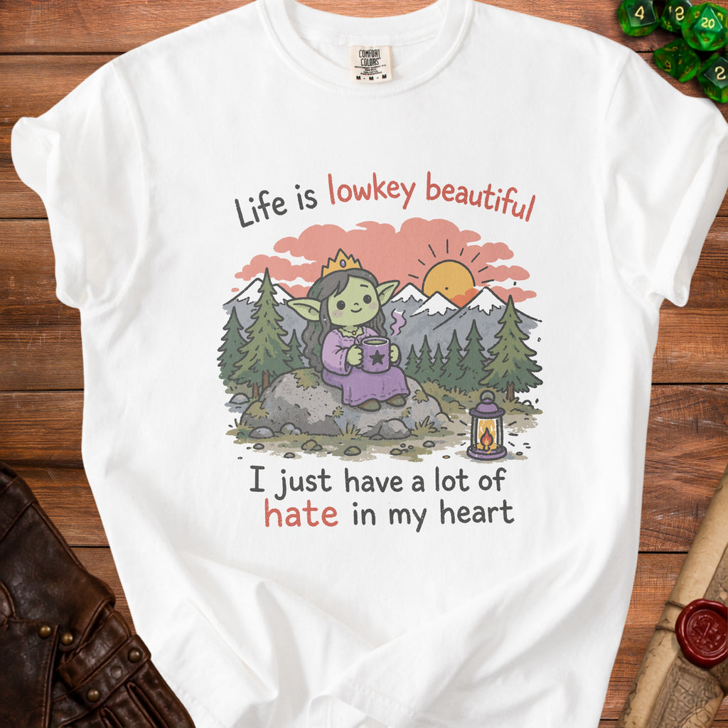White t-shirt with graphic of crowned goblin holding coffee, "Life is lowkey beautiful" and "I just have a lot of hate in my heart".