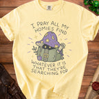 Yellow t-shirt with wizard mushroom graphic and text "I PRAY ALL MY HOMIES FIND WHATEVER IT IS THAT THEY'RE SEARCHING FOR."