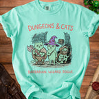 Mint green t-shirt with "Dungeons & Cats" graphic of three cats as barbarian, wizard, and rogue.