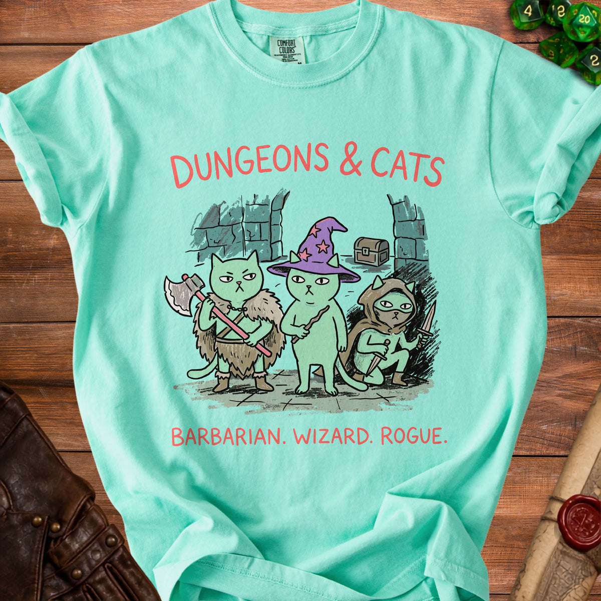 Mint green t-shirt with "Dungeons & Cats" graphic of three cats as barbarian, wizard, and rogue.