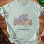 Light blue t-shirt with illustration of a goblin wizard sleeping on books and scroll of tasks.