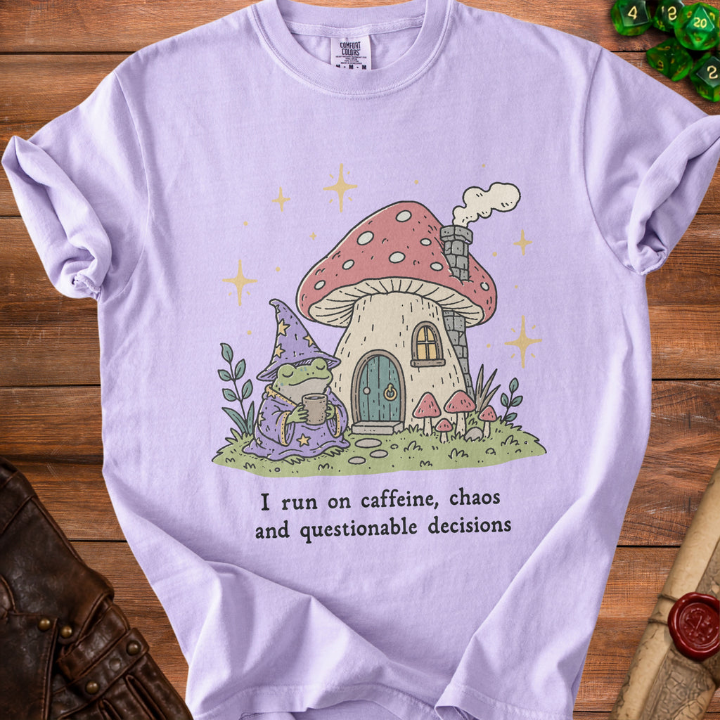Light purple t-shirt with wizard frog, mushroom house, and text "I run on caffeine, chaos and questionable decisions".