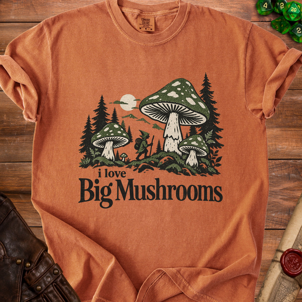 An orange t-shirt with a vintage graphic of a gnome, pine trees, and large mushrooms.