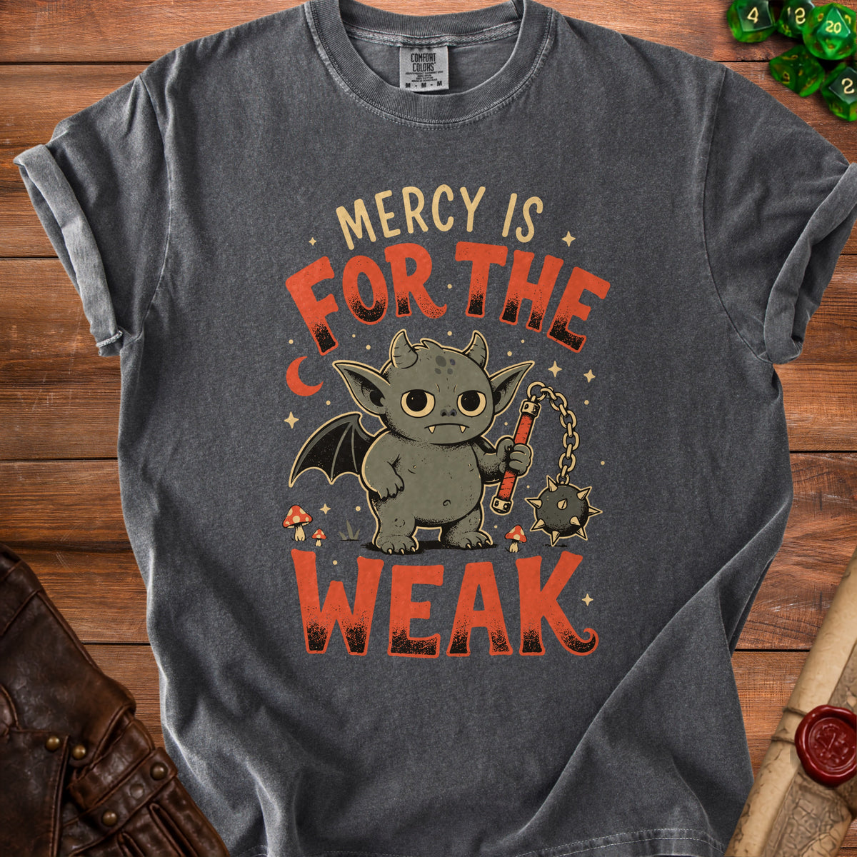 Dark grey t-shirt with a graphic of a small dragon-like creature holding a flail and text "Mercy is for the weak".