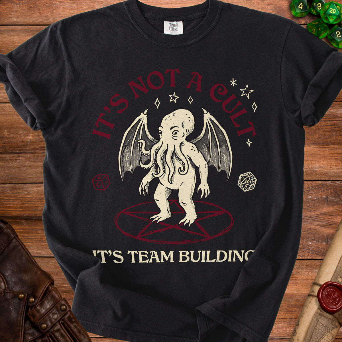 Black t-shirt with Cthulhu graphic, stars, dice, and "IT'S NOT A CULT 'T'S TEAM BUILDING" text.